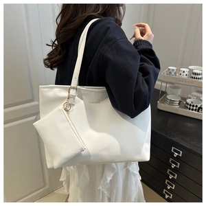 Detail of white leather tote set with gold FASHION text and matching inner pouch