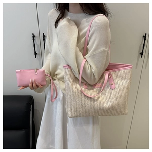 Detail of straw tote bag with pink leather trim and matching inner pouch set