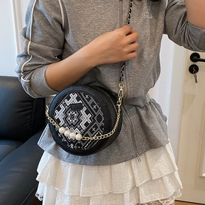 Modern round black handbag with ethnic embroidery and large pearl chain decoration