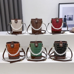 Mini pearl bucket bag in six colors featuring embossed stone pattern and gold buckle