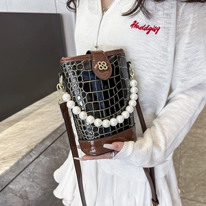 Black crocodile pattern bucket bag with pearl handle and gold clover clasp detail