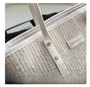 Detail of woven straw tote bag with reinforced metal rivets and stylish leather trim