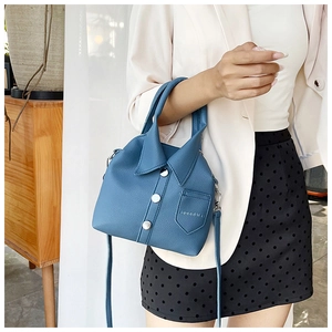 Detail of blue shirt-style handbag with lapel design, buttons and leather texture