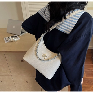 Détail du sac à bandoulière blanc crème plissé avec étoile dorée et chaîne argent