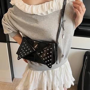 Chic black rivet underarm bag with glossy finish and asymmetric geometric fold design