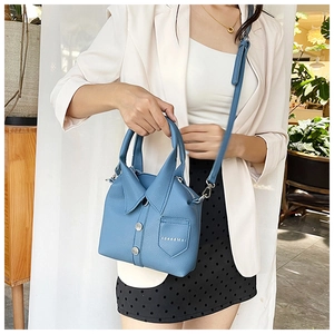 Detail of blue leather shirt-shaped handbag featuring lapel collar and adjustable strap