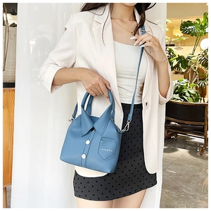 Detail of blue leather handbag with shirt collar design and white buttons