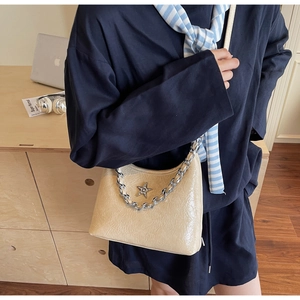 Détail du sac beige en cuir froissé avec étoile argentée et bandoulière en chaîne