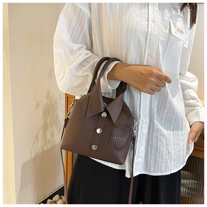 Detail of dark brown leather crossbody bag with shirt collar design and metal buttons
