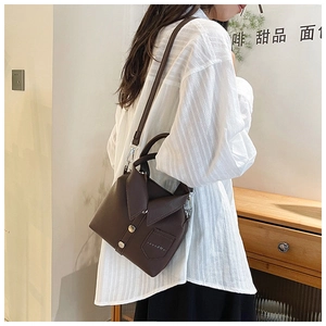 Detail of creative shirt-shaped dark brown leather handbag with buttons and lapel design