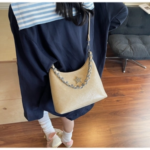 Détail du sac beige plissé en similicuir avec étoile en strass et chaîne argentée