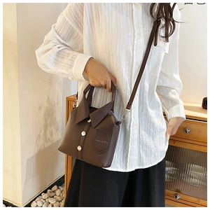 Detail of dark brown leather handbag featuring creative shirt collar design and buttons
