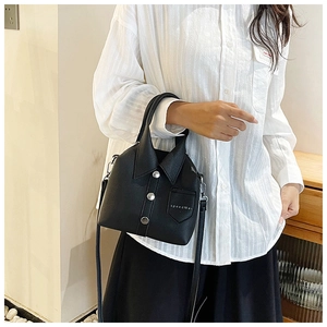 Close-up of shirt-style handbag detail featuring collar design and metal buttons