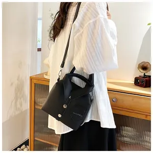 Detail of black shirt-style crossbody bag featuring collar design and silver hardware