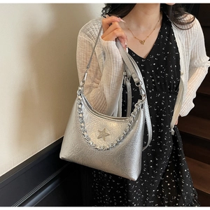Détail du sac argenté métallisé avec étoile en strass et bandoulière chaîne épaisse