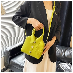 Detail of neon green shirt-shaped bag showing lychee leather texture and metal buttons