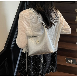 Détail du sac hobo argenté plissé avec étoile en strass et bandoulière en chaîne chic