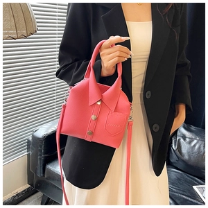 Detail of pink shirt-shaped handbag with button accents and textured leather finish