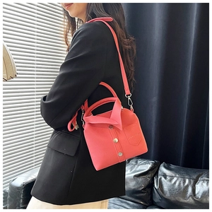 Detail of pink shirt-style handbag with lapel design and metallic buttons decoration