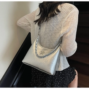 Vue détaillée d'un sac argenté plissé avec pendentif étoile et bandoulière chaîne