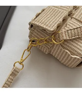 Detail of premium golden metal chain and hook on woven shoulder bag with wavy edge