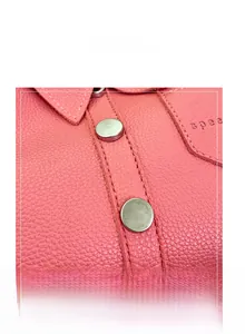 Detail of pink lychee grain leather handbag with silver hardware and logo embossing