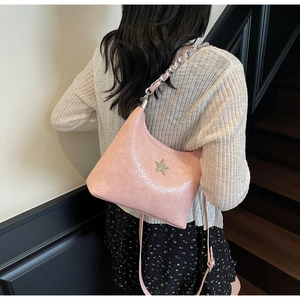 Détail du sac à bandoulière rose plissé avec une étoile brillante et chaîne métal