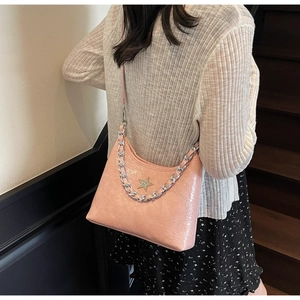 Détail du sac bandoulière en cuir verni plissé rose avec emblème étoile et chaîne argent