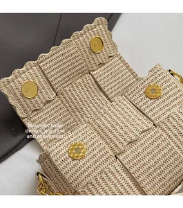 Detail of woven square bag with wavy edges and gold magnetic closure design