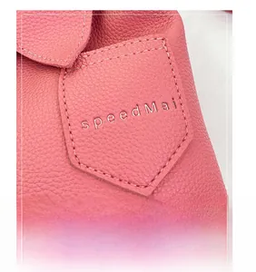 Macro shot of pink lychee grain leather with a stitched pocket and silver speedMai logo