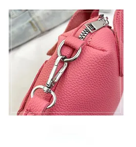 Close-up of pink lychee leather texture and durable silver metal hook on handbag