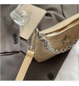 Vue détaillée du sac crème en cuir froissé brillant avec breloque étoile argentée