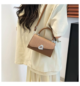 Brown faux leather crossbody bag featuring a woven flap and heart-shaped silver metal clasp