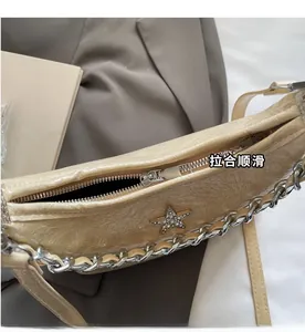 Détail de la fermeture éclair en métal et de la doublure du sac beige orné d'étoiles