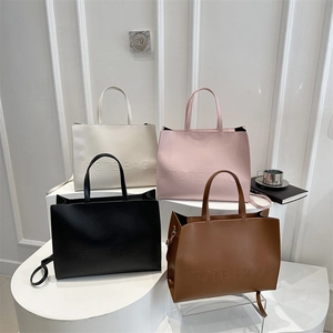 Minimalist faux leather tote bags in four colors with embossed text and top handles