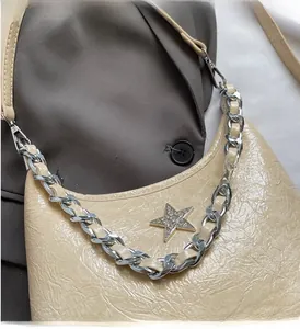 Détail du sac en cuir verni beige plissé avec chaîne argentée et étoile en strass