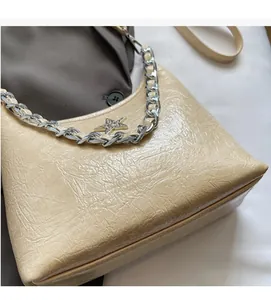 Gros plan sur un sac plissé beige avec chaîne argentée et étoile en strass brillant