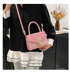 Detailed close-up of pink leather crossbody bag with fabric texture and gold lock