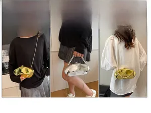 Dettaglio pochette metallica irregolare con manico di perle e catena rimovibile