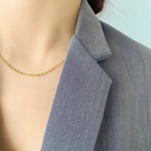 Détail du collier à billes plaqué or montrant des perles polies sur une chaîne fine