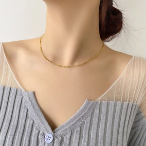 Gros plan d'un collier ras du cou perlé plaqué or minimaliste sur le cou d'un mannequin