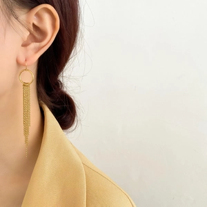 Détail de boucles d'oreilles pompons en or 18 carats avec chaînes serpent sur modèle