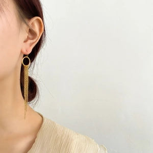 Gros plan d'élégantes boucles d'oreilles à longs glands dorés sur des crochets