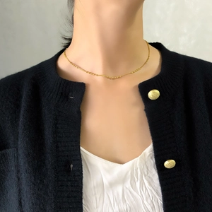 Gros plan d'un collier de perles géométriques plaqué or sur le cou d'un mannequin