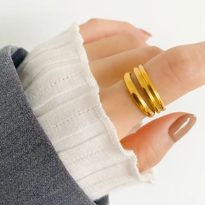 Dettaglio di doppi anelli dorati su una mano femminile per un look minimalista
