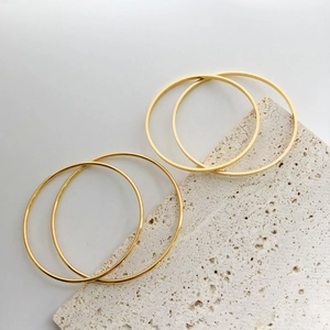 Minimalist gold plated titanium steel bangles set with polished finish on stone