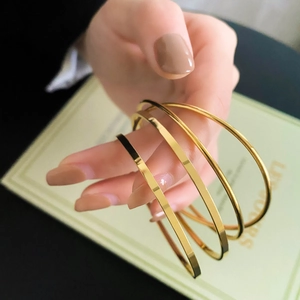 Set of three polished gold minimalist bangles for women shown on a model wrist