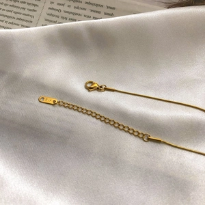 Detailed macro view of gold snake chain necklace with K18 stamp on the clasp and extension