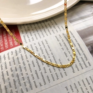 Collier chaîne à maillons nez de cochon doré en acier inoxydable sur porcelaine blanche