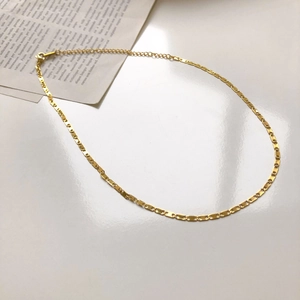 Détail d'un collier chaîne à maillons rectangulaires dorés avec fermoir mousqueton